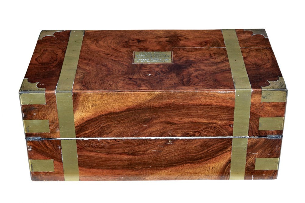 A 19th-century mahogany writing slope featuring polished brass corner mounts, horizontal brass bands, and a central engraved brass plaque. View VI