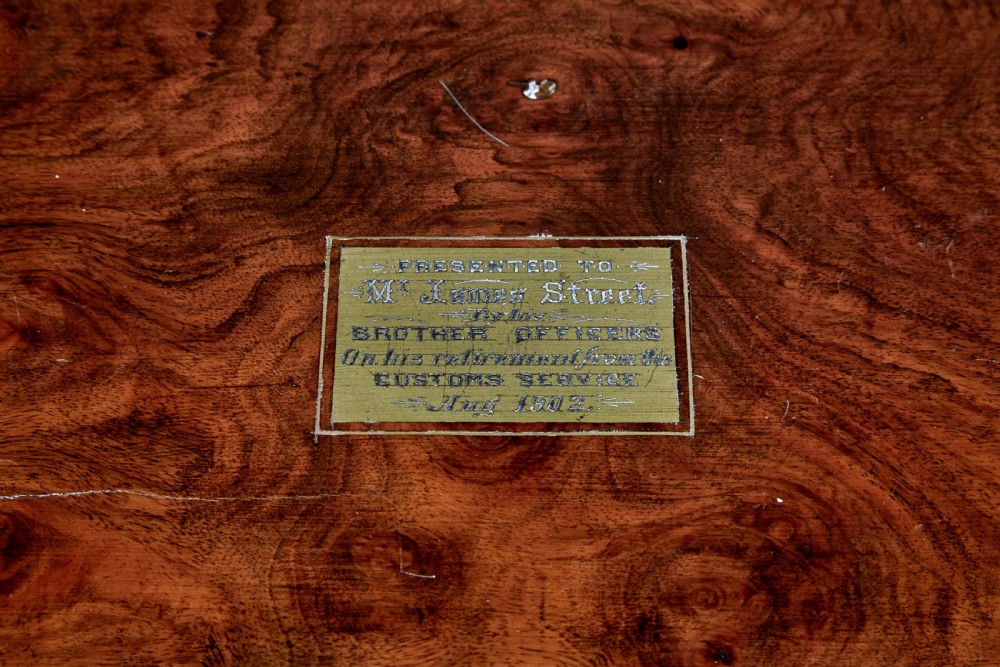 A 19th-century mahogany writing slope featuring polished brass corner mounts, horizontal brass bands, and a central engraved brass plaque. View VIII