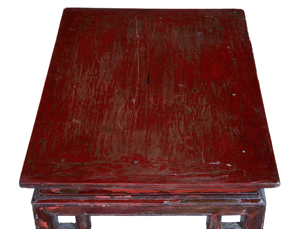 An 18th-century Chinese low table featuring a distressed red lacquer finish, straight square legs, and geometric openwork aprons. View VII