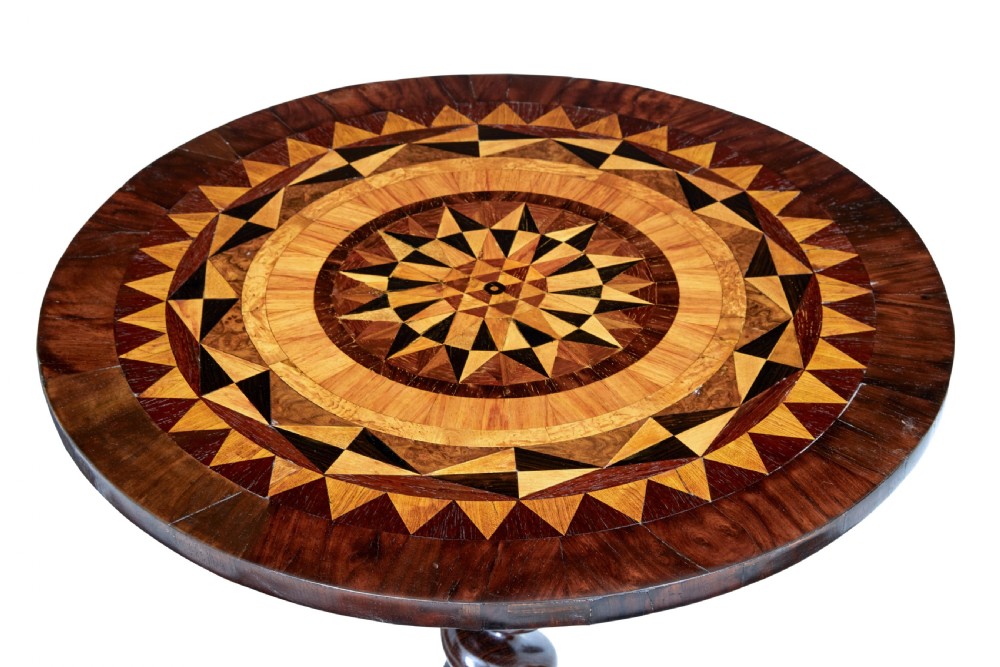 An early Victorian dark walnut tilt top occasional table featuring geometric starburst inlay on a circular top supported by a spiral barley twist pedestal and carved tripod legs. View V