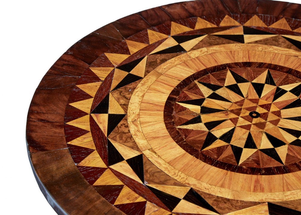 An early Victorian dark walnut tilt top occasional table featuring geometric starburst inlay on a circular top supported by a spiral barley twist pedestal and carved tripod legs. View VI