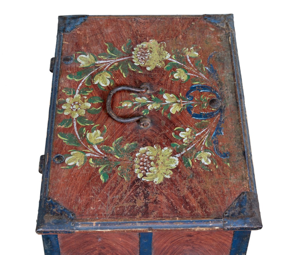 An antique rectangular Swedish wooden box featuring a reddish brown finish with blue painted metal corner straps, a floral lid design, and the painted date 1806. View III