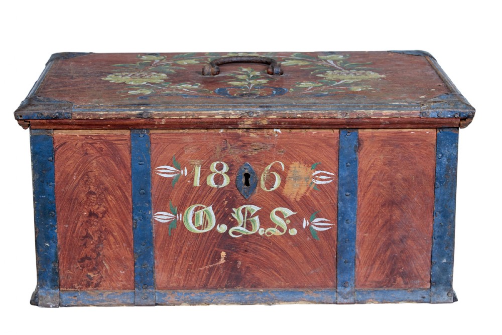 An antique rectangular Swedish wooden box featuring a reddish brown finish with blue painted metal corner straps, a floral lid design, and the painted date 1806. View V