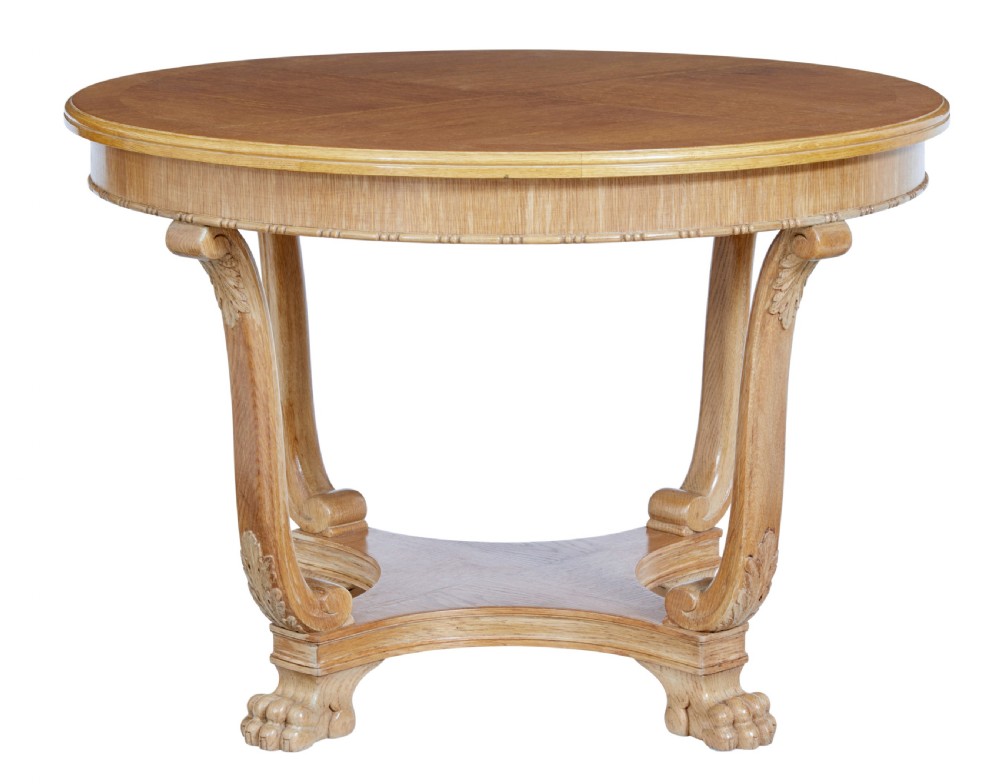 A circular oak occasional table with a parquetry top, carved legs, and paw feet on a white background. View II