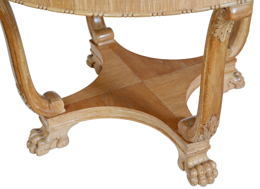 A circular oak occasional table with a parquetry top, carved legs, and paw feet on a white background. View III