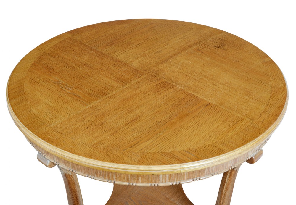 A circular oak occasional table with a parquetry top, carved legs, and paw feet on a white background. View IV