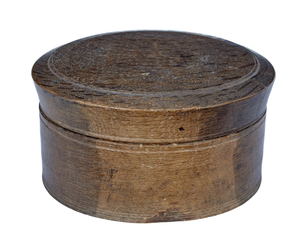 A small round early 19th-century Swedish oak lidded box with turned circular grooves around the rim.