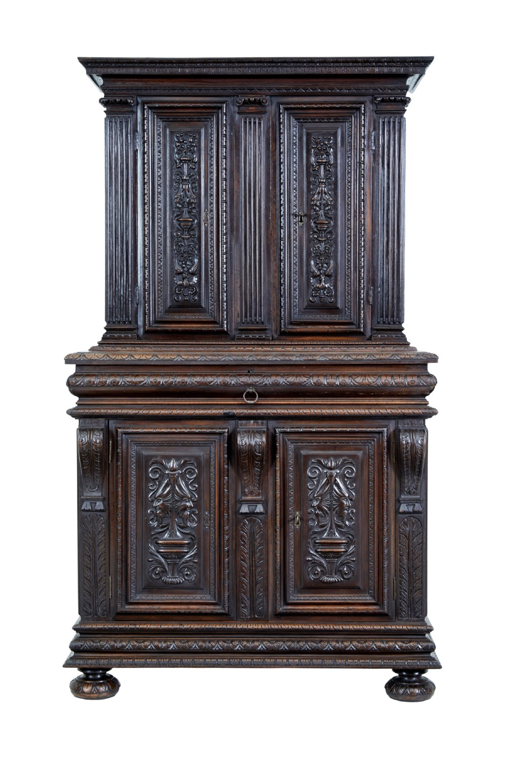 A two-section mid-19th century dark walnut cabinet featuring detailed relief carvings on the panelled doors, fluted columns, and flattened bun feet.
