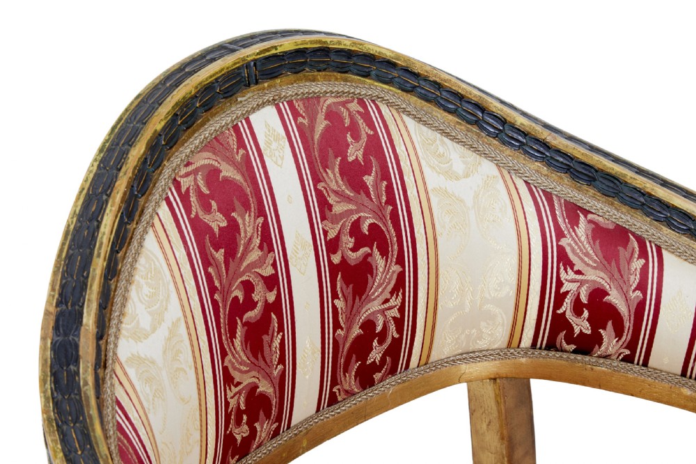 A pair of 19th-century Swedish giltwood armchairs featuring curved backs, black carved terminals with female heads, and red and cream striped fabric upholstery. View IX