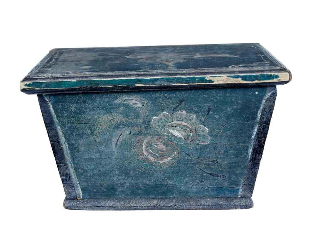A small 19th-century wooden sarcophagus box featuring distressed blue paint, white hand-painted decorative flourishes, and a central diamond-shaped iron keyhole escutcheon. View V