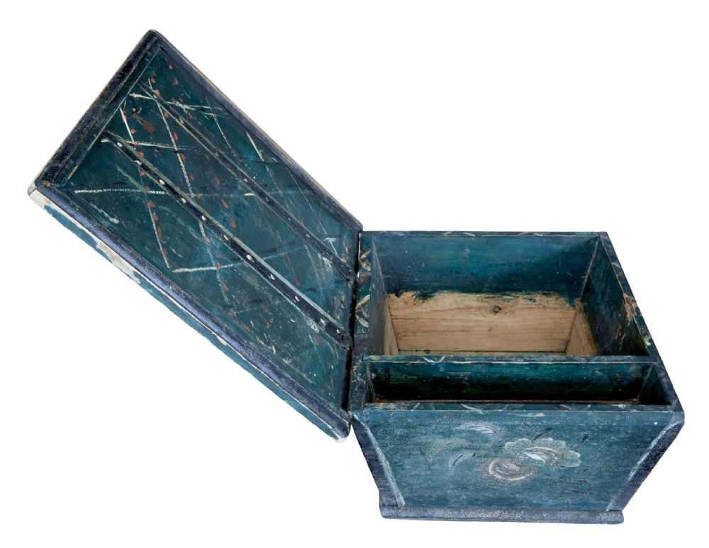 A small 19th-century wooden sarcophagus box featuring distressed blue paint, white hand-painted decorative flourishes, and a central diamond-shaped iron keyhole escutcheon. View VII