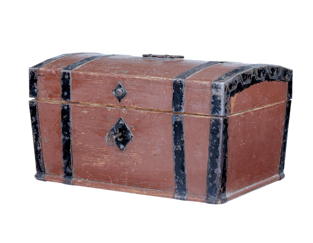 A nineteenth-century Scandinavian pine box featuring a domed lid, terracotta red painted finish, black iron straps, and a central diamond escutcheon with key.