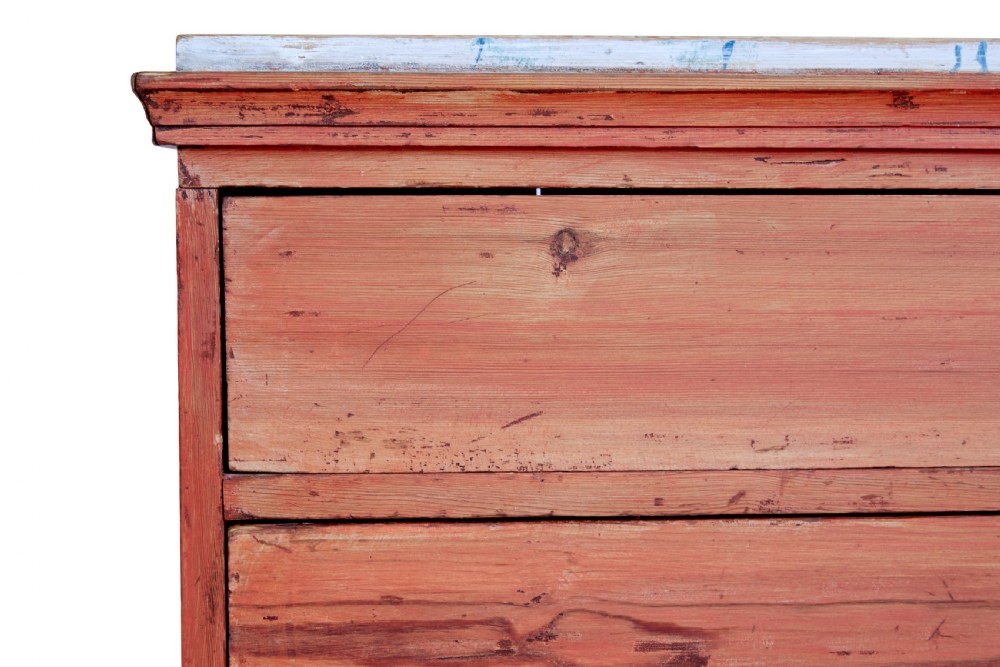 An early 19th-century Swedish pine chest of drawers featuring four graduated drawers with terracotta red paint and central metallic escutcheons. View VII