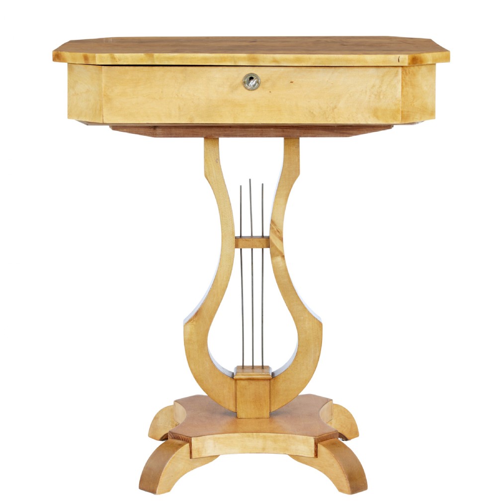 A 19th-century Swedish satin birch occasional table featuring a lyre-shaped pedestal base, a single drawer with a key, and a quadruped plinth. View II