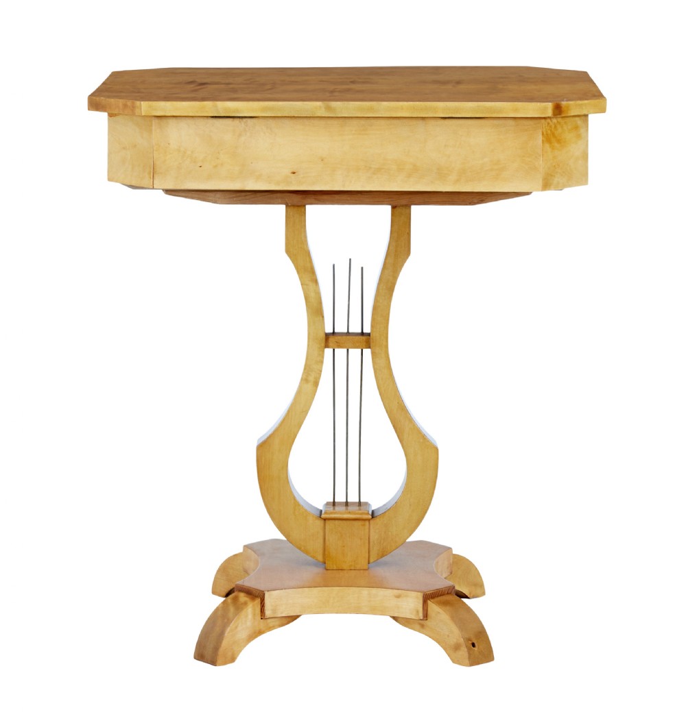 A 19th-century Swedish satin birch occasional table featuring a lyre-shaped pedestal base, a single drawer with a key, and a quadruped plinth. View VI