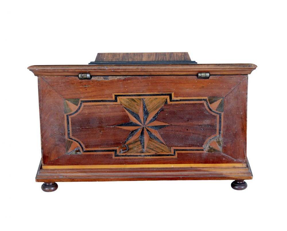 A 19th-century fruitwood desktop box featuring geometric marquetry star motifs, a raised stepped lid, keyhole, and small turned feet. View III