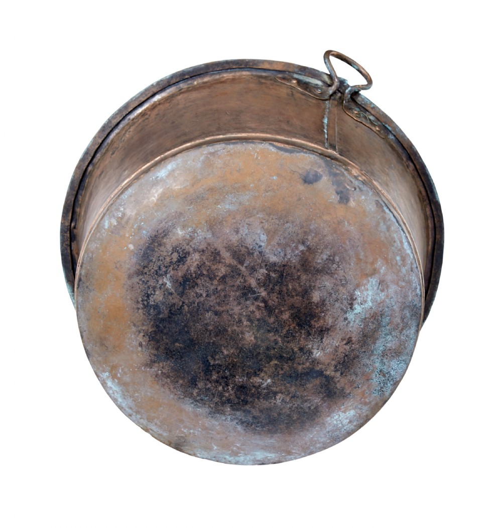 A large 19th-century hammered copper cooking vessel featuring a rounded base, riveted seams, and two wrought iron loop handles. View VI
