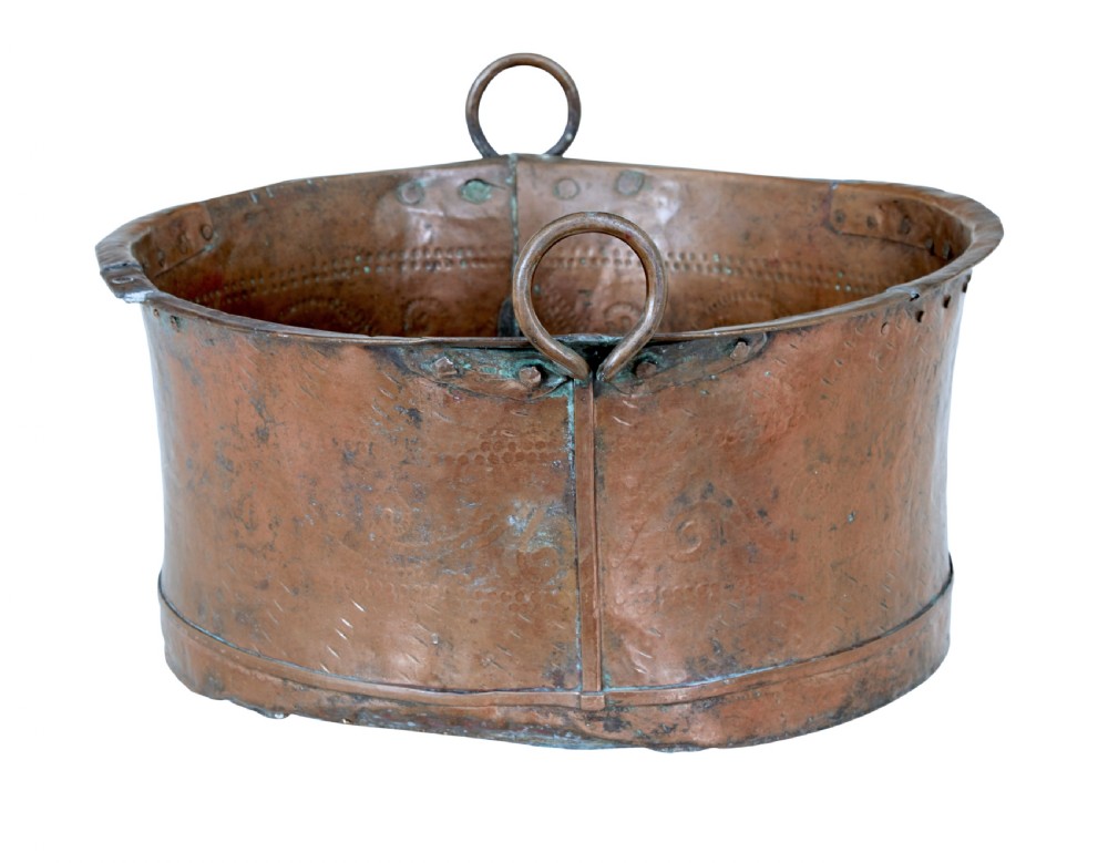A large 19th-century copper pot with embossed spiral patterns, riveted side seams, a wide flared rim, and two round metal ring handles. View II
