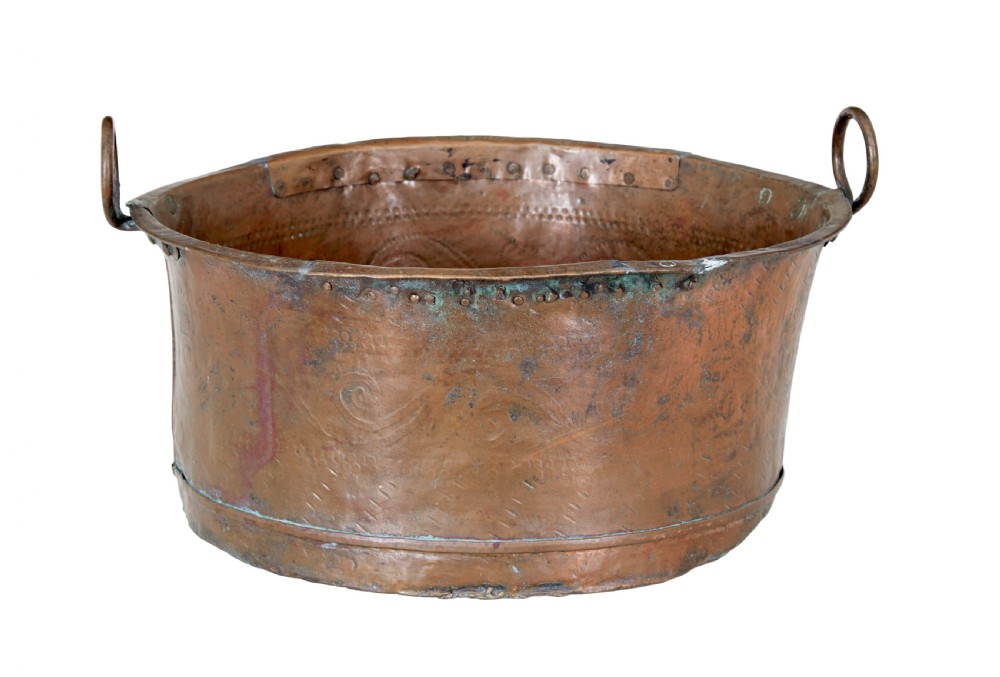 A large 19th-century copper pot with embossed spiral patterns, riveted side seams, a wide flared rim, and two round metal ring handles. View III
