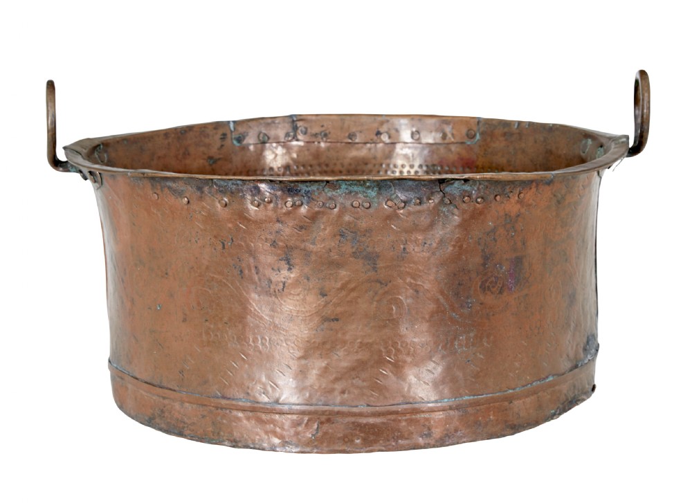 A large 19th-century copper pot with embossed spiral patterns, riveted side seams, a wide flared rim, and two round metal ring handles. View VII