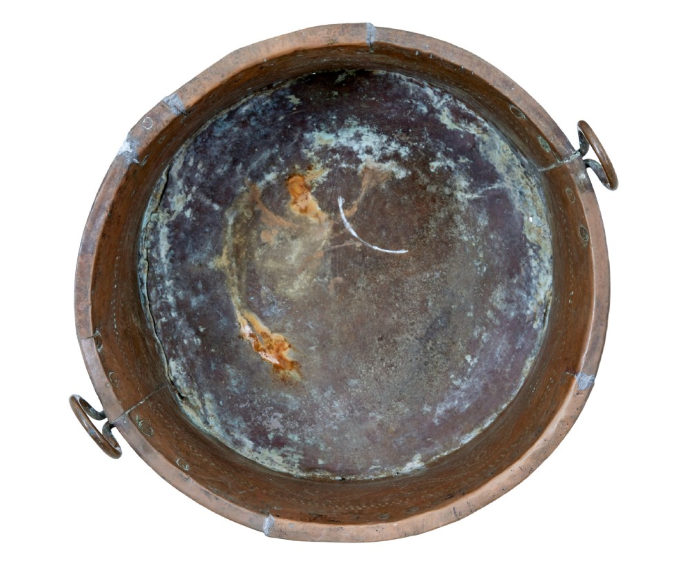 A large 19th-century copper pot with embossed spiral patterns, riveted side seams, a wide flared rim, and two round metal ring handles. View VIII