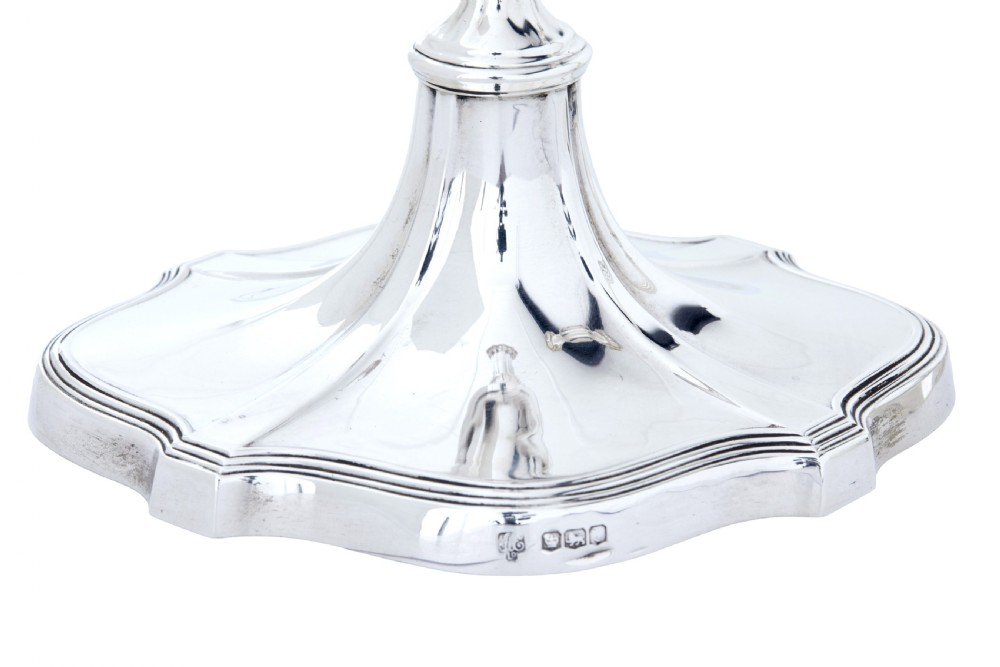 A pair of polished early twentieth century sterling silver candlesticks featuring fluted tapering stems and shaped stepped bases with hallmark stamps. View III