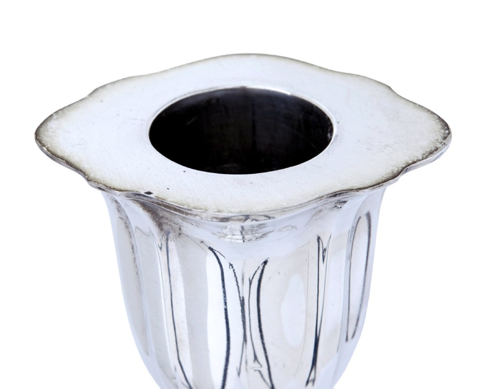 A pair of polished early twentieth century sterling silver candlesticks featuring fluted tapering stems and shaped stepped bases with hallmark stamps. View VII