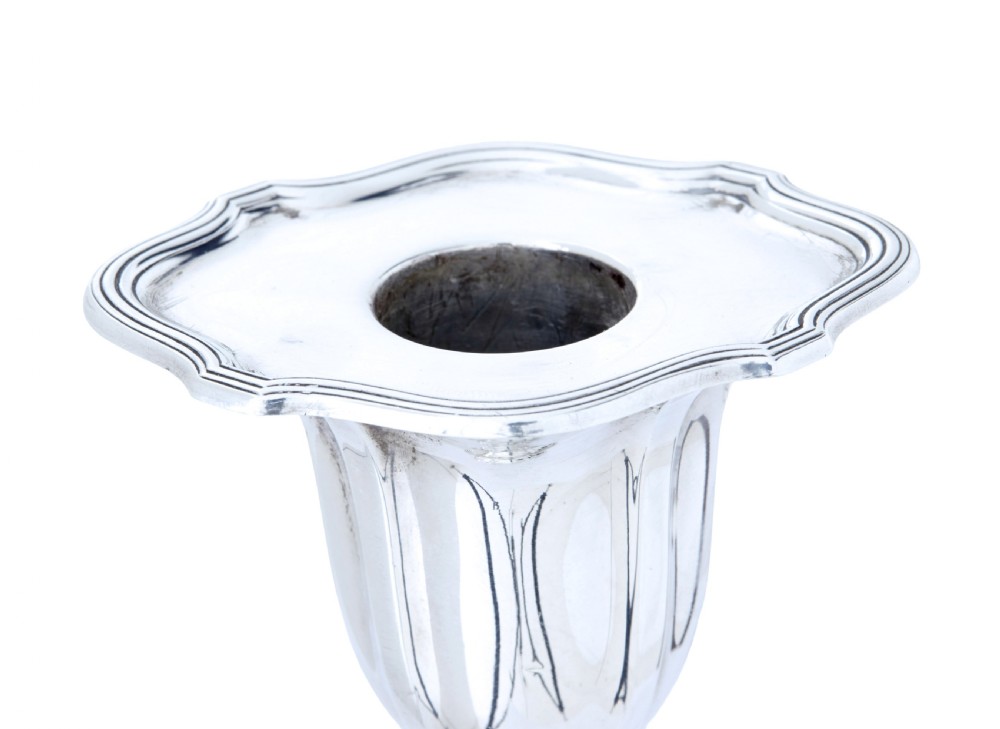 A pair of polished early twentieth century sterling silver candlesticks featuring fluted tapering stems and shaped stepped bases with hallmark stamps. View VIII