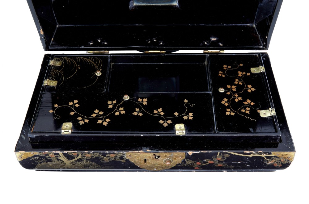 A 19th-century black lacquered jewellery box decorated with gilded botanical motifs, an ornate brass clasp, and a pale blue padded silk top. View III