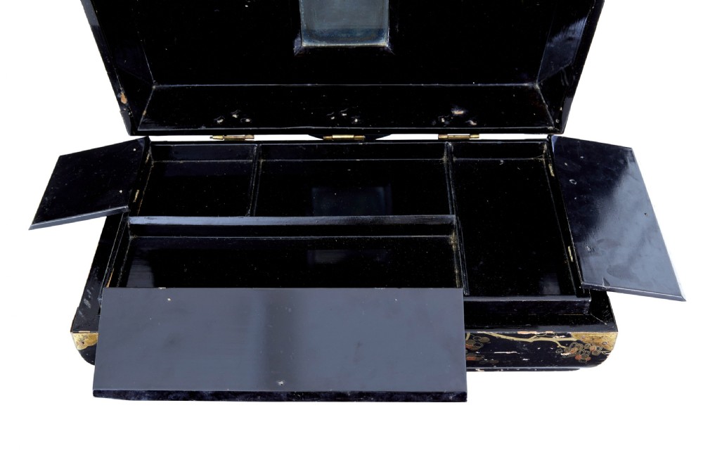 A 19th-century black lacquered jewellery box decorated with gilded botanical motifs, an ornate brass clasp, and a pale blue padded silk top. View IV