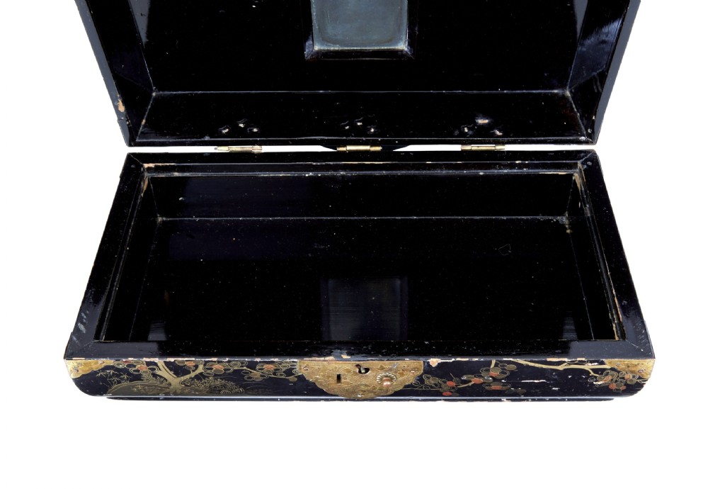 A 19th-century black lacquered jewellery box decorated with gilded botanical motifs, an ornate brass clasp, and a pale blue padded silk top. View V