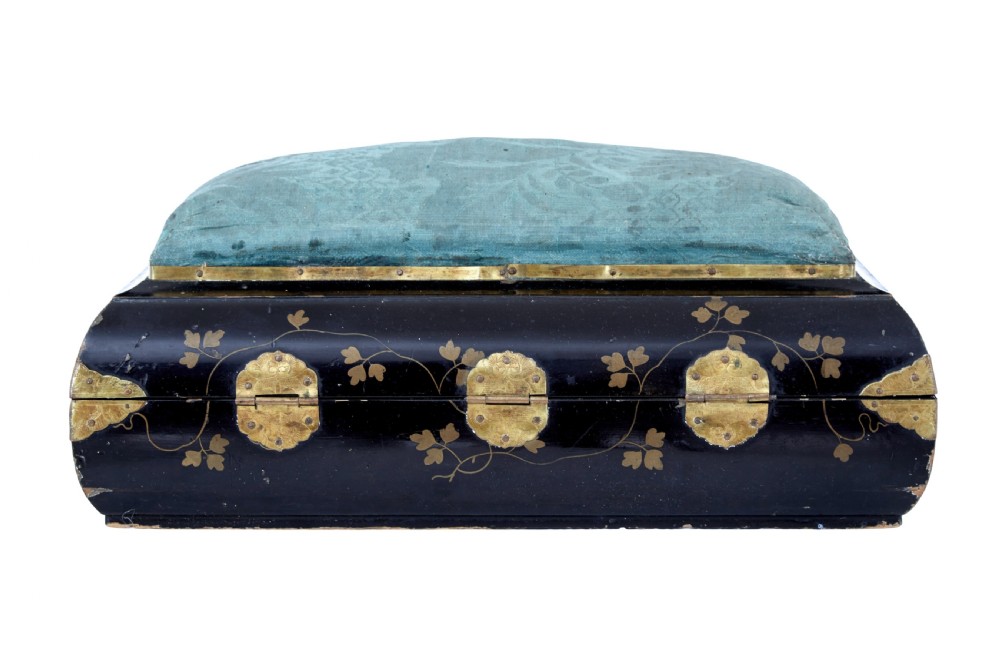 A 19th-century black lacquered jewellery box decorated with gilded botanical motifs, an ornate brass clasp, and a pale blue padded silk top. View X