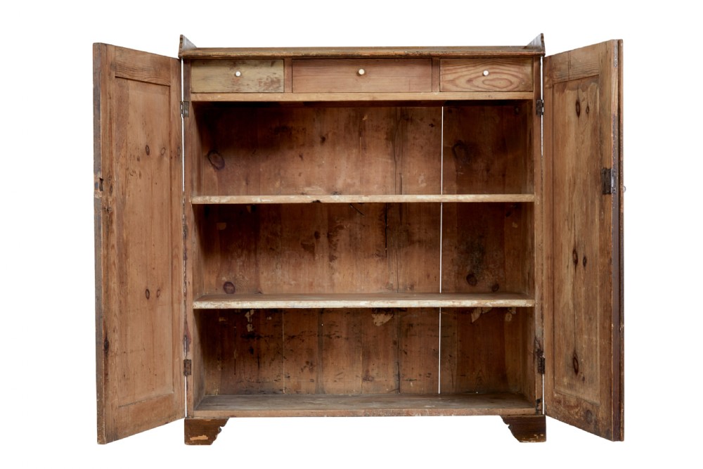 A 19th-century Swedish pine cupboard featuring two panelled doors with faux-wood grain paintwork and a low shaped splashback. View II