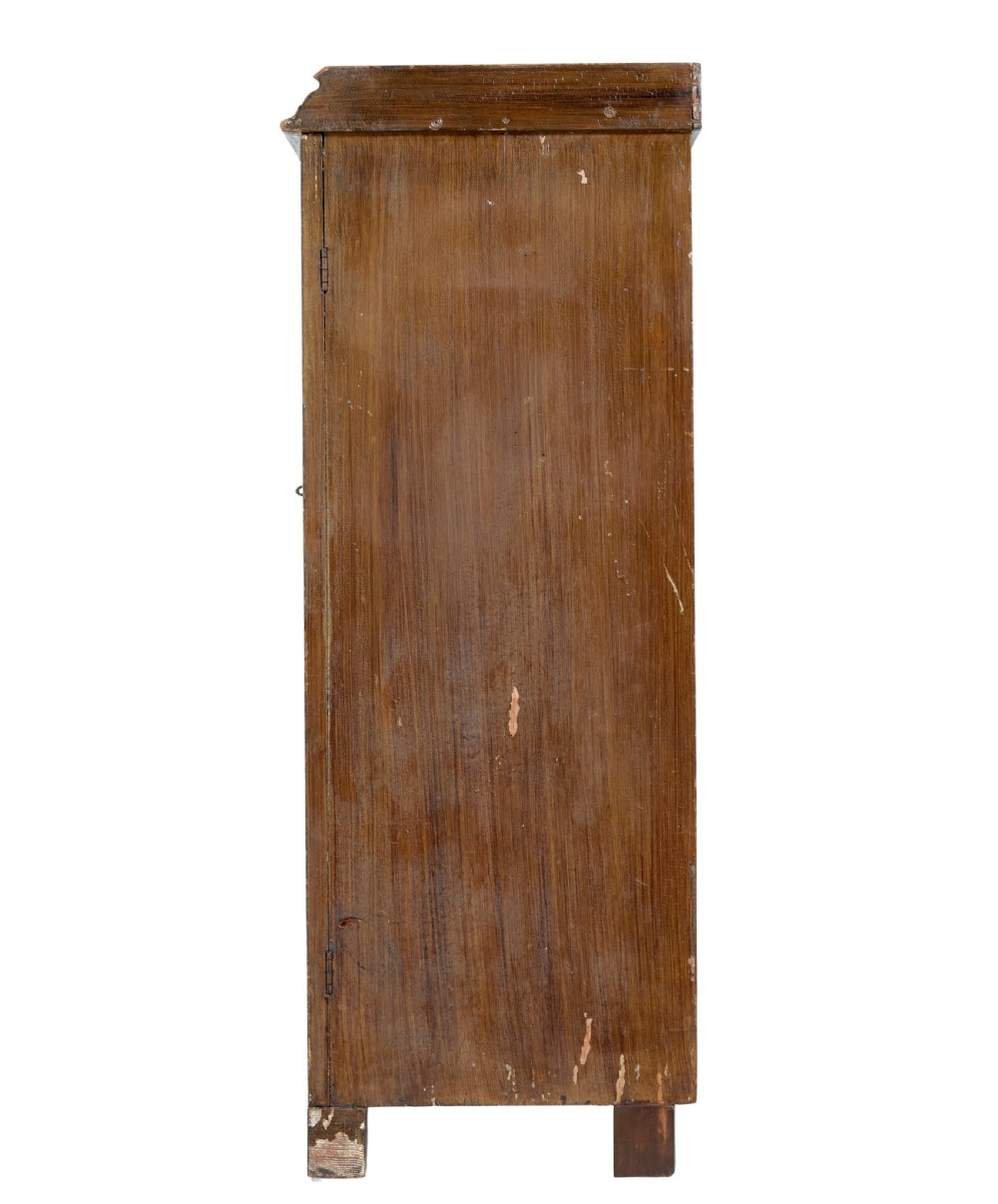 A 19th-century Swedish pine cupboard featuring two panelled doors with faux-wood grain paintwork and a low shaped splashback. View VI