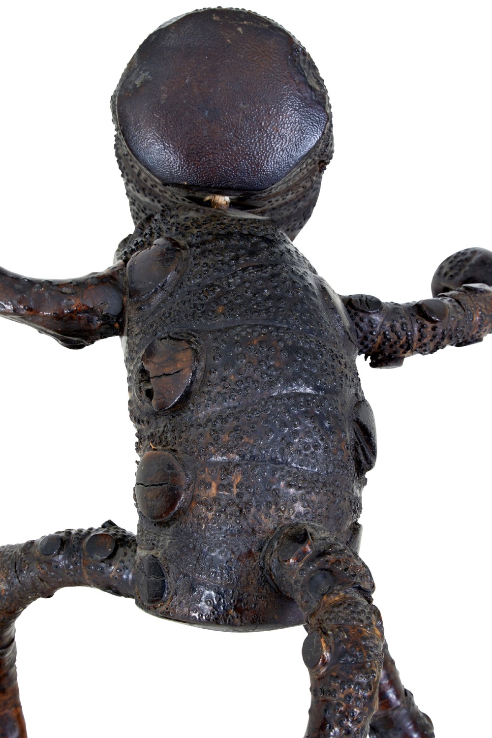 A dark brown hand-carved mango wood novelty figure with inset yellow glass eyes and long textured limbs. View IX