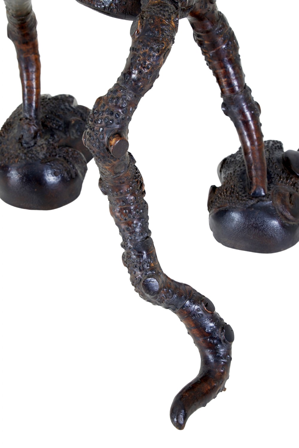 A dark brown hand-carved mango wood novelty figure with inset yellow glass eyes and long textured limbs. View X