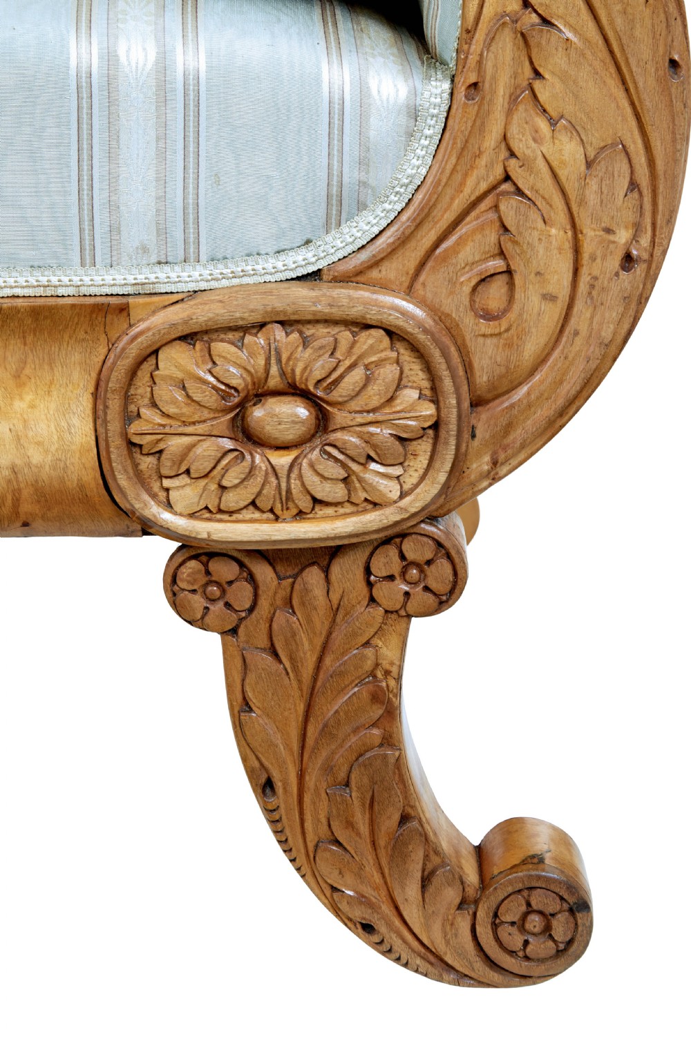 A 19th-century Swedish carved birch sofa featuring scrolled arms, floral rosettes, swept feet, and light blue and white striped upholstery. View X