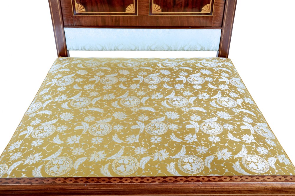 A nineteenth-century mahogany four-poster bed frame featuring carved posts with pink porcelain sections, marquetry panelling, and an ornate trefoil canopy trim. View XV