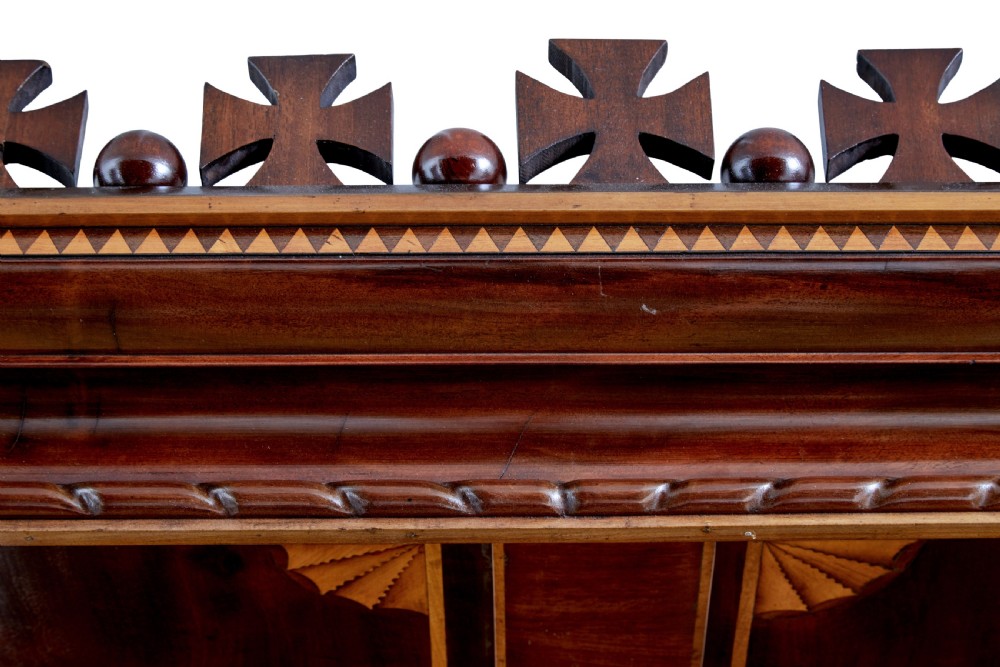 A nineteenth-century mahogany four-poster bed frame featuring carved posts with pink porcelain sections, marquetry panelling, and an ornate trefoil canopy trim. View XVI