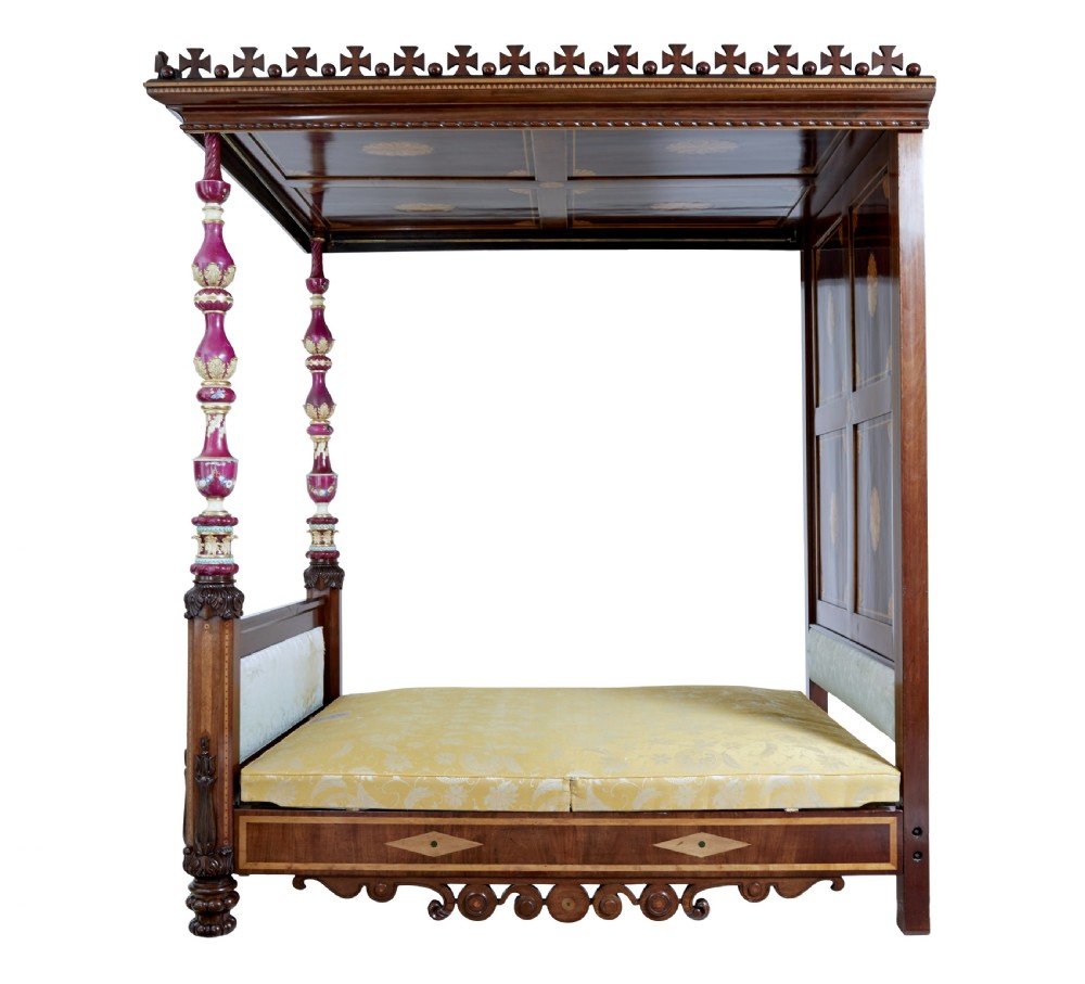 A nineteenth-century mahogany four-poster bed frame featuring carved posts with pink porcelain sections, marquetry panelling, and an ornate trefoil canopy trim. View XVII