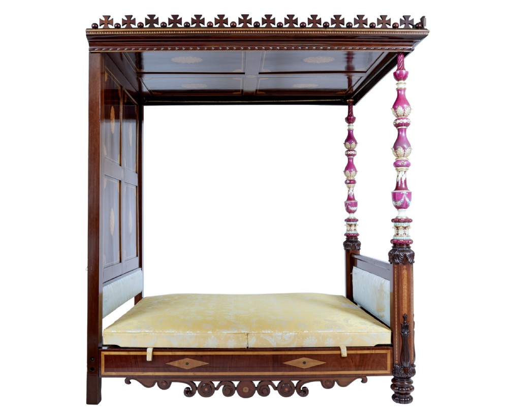 A nineteenth-century mahogany four-poster bed frame featuring carved posts with pink porcelain sections, marquetry panelling, and an ornate trefoil canopy trim. View XIX