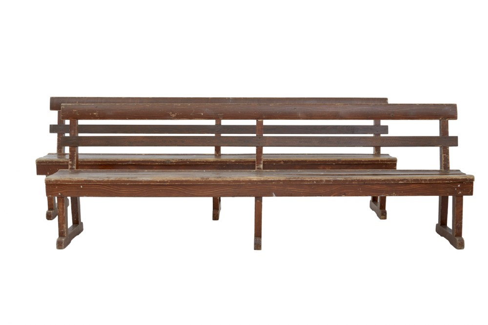 A pair of long, rustic pine benches with slatted backrests, trestle-style legs, and a distressed reddish-brown painted finish. View II