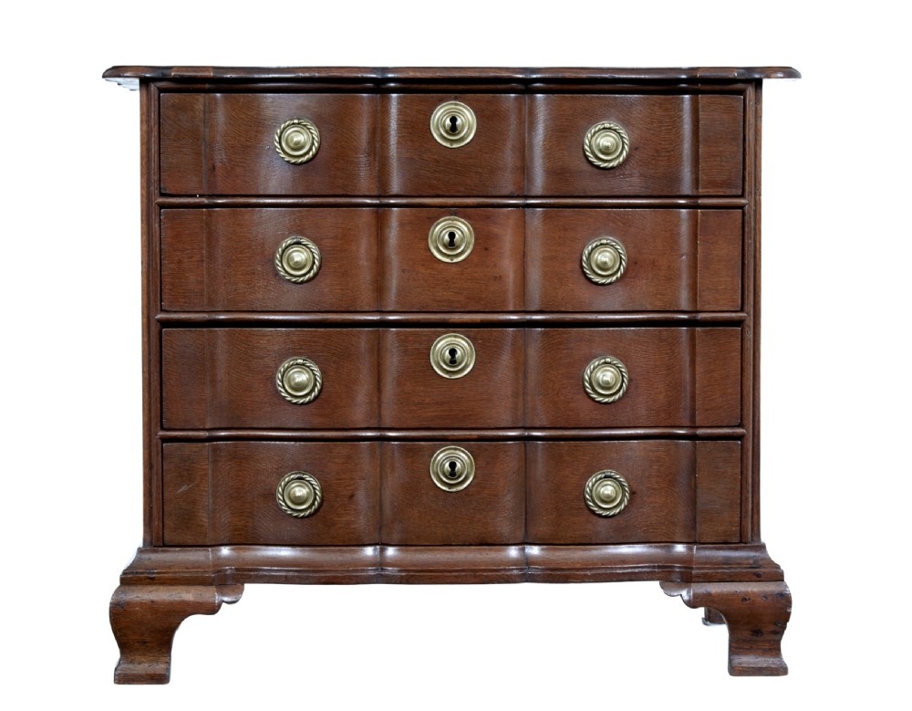 A 19th-century oak chest featuring four graduated drawers with shaped fronts, brass ring handles, keyhole escutcheons, and bracket feet. View II