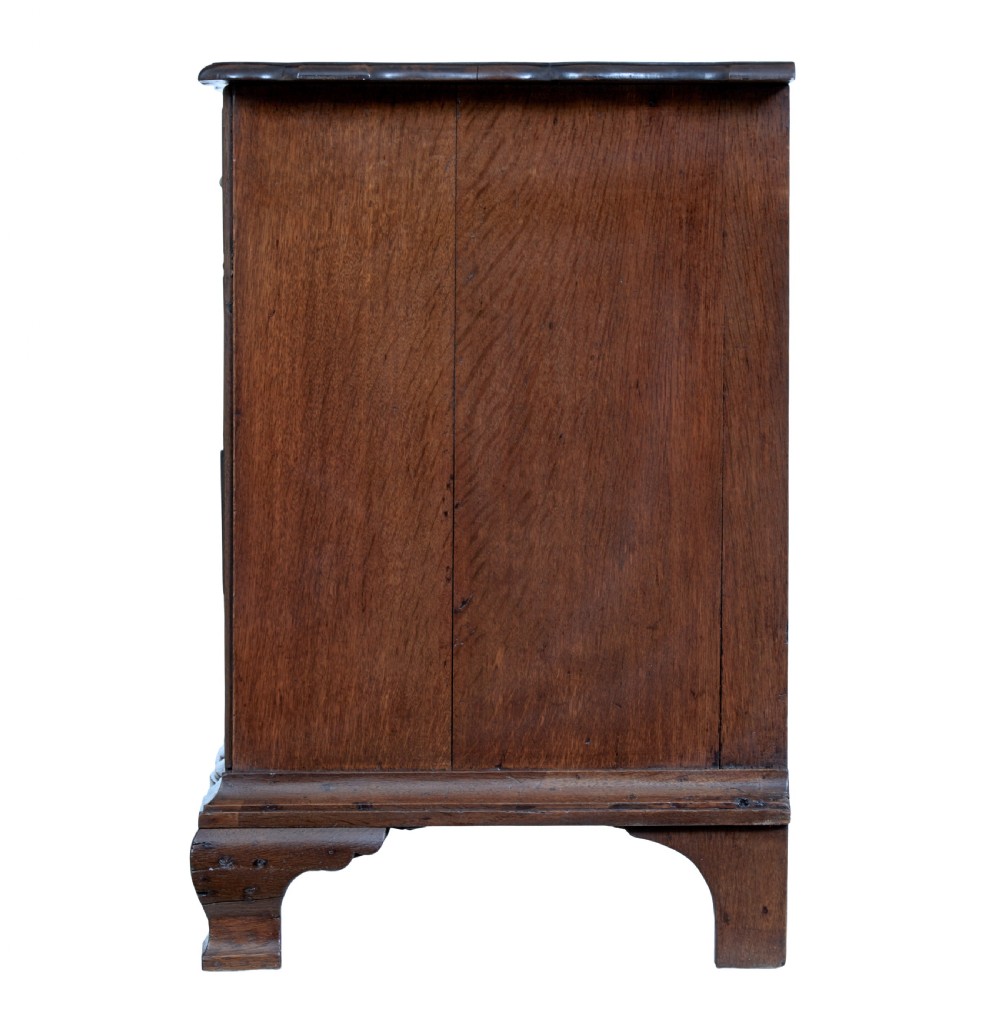 A 19th-century oak chest featuring four graduated drawers with shaped fronts, brass ring handles, keyhole escutcheons, and bracket feet. View III