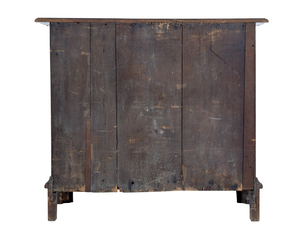 A 19th-century oak chest featuring four graduated drawers with shaped fronts, brass ring handles, keyhole escutcheons, and bracket feet. View V