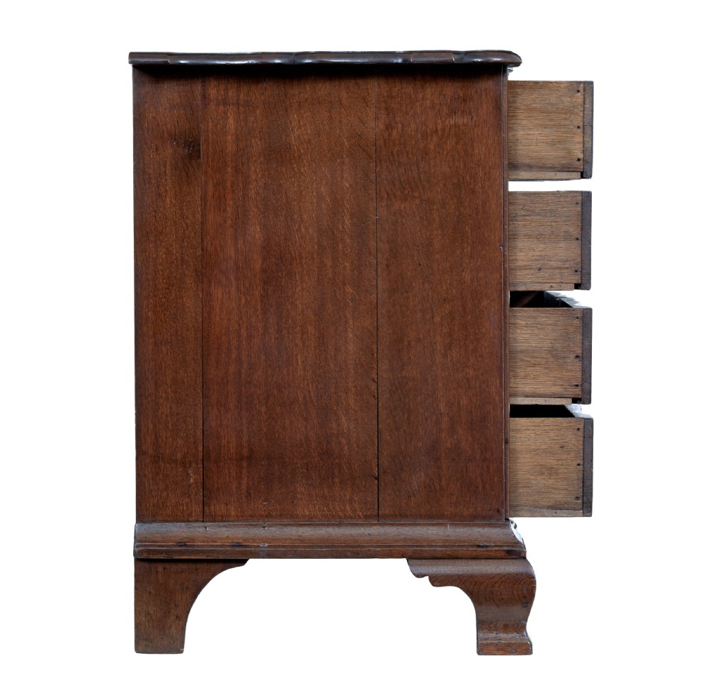 A 19th-century oak chest featuring four graduated drawers with shaped fronts, brass ring handles, keyhole escutcheons, and bracket feet. View VI