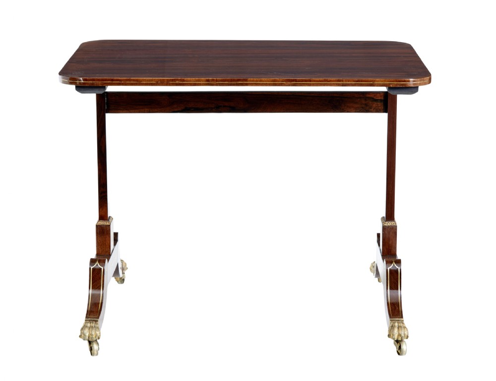 An early 19th-century Regency dark wood side table with delicate brass inlay, trestle base, and brass claw feet on castors. View II