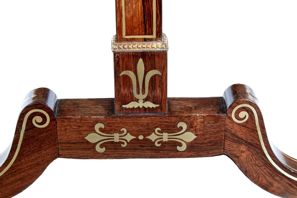 An early 19th-century Regency dark wood side table with delicate brass inlay, trestle base, and brass claw feet on castors. View VII