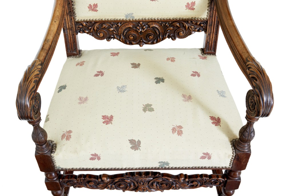 Pair of 19th-century French carved walnut armchairs with high rectangular backs, scroll arms, and cream leaf-patterned upholstery. View II
