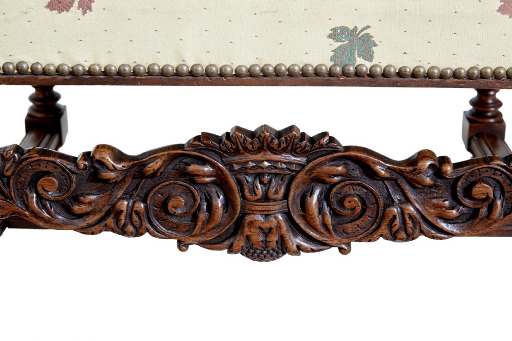 Pair of 19th-century French carved walnut armchairs with high rectangular backs, scroll arms, and cream leaf-patterned upholstery. View V